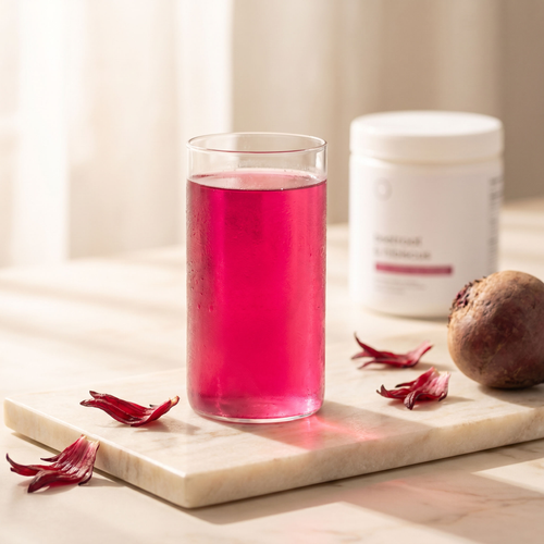 Glass of Vermel beetroot hibiscus drink with fresh petals and beet